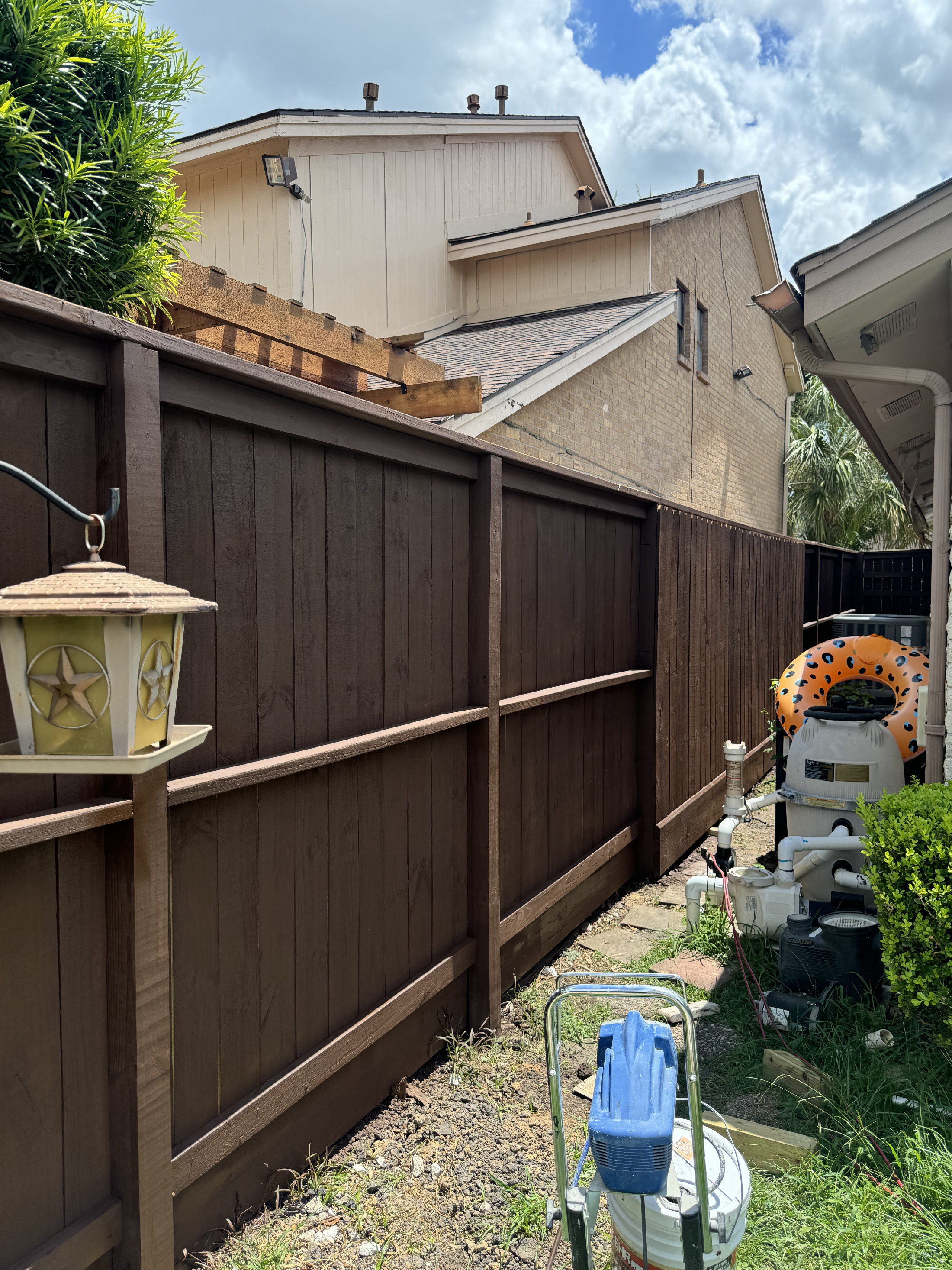 Wooden fence installation with dark walnut stain